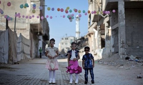  Idul Fitri di Berbagai Negara di Tengah Pandemi dan Konflik. Tiga anak Palestina berfoto bersama saat merayakan Hari Raya Idul Fitri di Gaza, Palestina, Jumat (17/7).  (AP/Khalil Hamra)