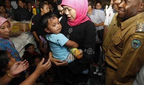 Menteri Sosial Khofifah Indar Parawansa mengendong balita di tenda pengungsian korban peristiwa penyerangan sekelompok massa beberapa waktu yang lalu di Distrik Karubaka, Tolikara, Papua, Selasa (21/7).  (Antara/Trisnadi)