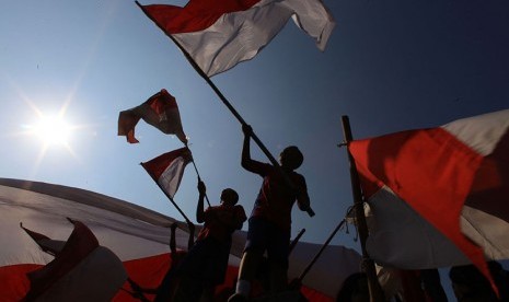 Siswa mengibarkan bendera merah putih pada acara Pesta Bendera di Monumen Mayor Achmadi, Banjarsari, Solo, Jawa Tengah, Selasa, (11/8). 