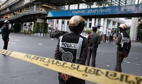  Personil polisi berjaga di lokasi ledakan bom di pusat kota Bangkok, Senin (17/8).