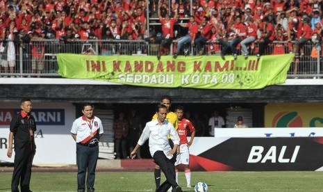 Presiden Joko Widodo (tengah) didampingi Ketua Penyelenggara Erick Thohir (kedua kiri) dan Gubernur Bali Made Mangku Pastika (kiri) menendang bola saat membuka pertandingan Piala Presiden di Stadion Dipta, Gianyar, Ahad (30/8). 