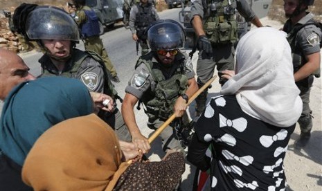 Tentara Israel menghalau pengunjuk rasa wanita Palestina.