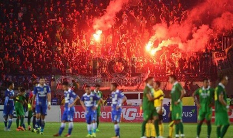  Sejumlah pendukung Persebaya menyalakan flare usai pertandingan Persib Bandung melawan Persebaya United di stadion Si Jalak Harupat, Kabupaten Bandung, Ahad (6/9). (foto : Septianjar Muharam)