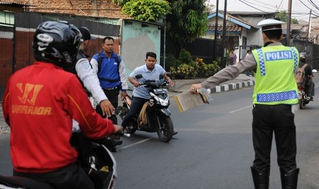 Petugas Ditlantas Polda Metro Jaya dibantu petugas Dishub Jakarta Selatan memberhentikan pengendara motor yang melawan arus saat razia di kawasan Tanjung Barat, Jakarta Selatan, Rabu (9/9).(Antara/Indrianto Eko Suwarso)