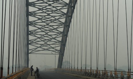 Warga berada di Jembatan Aur Duri II Sungai Batanghari yang tertutup kabut asap di Jambi, Rabu (9/9).   (Antara/Wahyu Putro A)