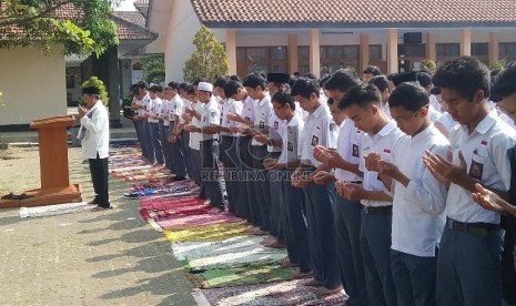  Siswa beserta guru SMAN 8 Bandung, Senin (14/9), melakukan shalat ghaib bersama di halaman sekolah, untuk mendoakan para korban tewas akibat robohnya crane di Masjidil Haram pada Jumat (11/9) lalu. (foto : Adys)