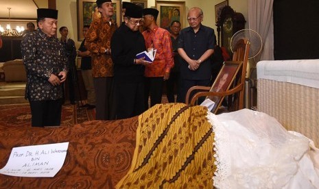 Presiden ketiga RI BJ Habibie (tengah) membaca Surat Yasin saat melayat almarhum Menteri Keuangan tahun 1968-1983 Ali Wardhana di rumah duka, Jakarta, Senin (14/9). (Antara/Akbar Nugroho Gumay)