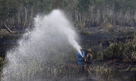  Petugas Badan Penanggulangan Bencana Daerah (BPBD) Kabupaten Ogan Ilir melakukan pemadaman kebakaran lahan gambut dari udara di Daerah Sei Rambutan, Ogan Ilir, Indralaya, Sumatera Selatan, Kamis (17/9).  (Antara/Nova Wahyudi)