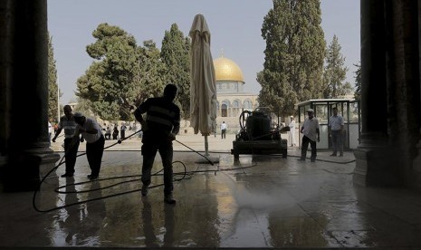 Warga Palestina membersihkan puing-puing akibat serangan polisi Israel ke komplek Masjid Al Aqsa di Yerusalem.