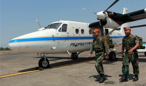 Personel TNI AU melintasi pesawat Twin Otter yang sama jenisnya dengan pesawat Aviastar PK-BRM yang hilang kontak.