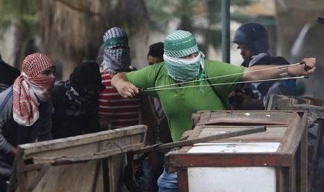   Pengunjuk Palestina bentrok dengan pasukan pendudukan Israel di Hebron, Palestina  Sabtu (10/10).  (REUTERS/Mussa Qawasma)