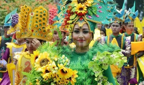 Sejumlah remaja dari Provinsi Gorontalo memakai kostum bunga berwarna-warni pada helaran budaya Kemilau Nusantara 2015 di depan Gedung Sate, Kota Bandung, Ahad (25/10). (Republika/Edi Yusuf)