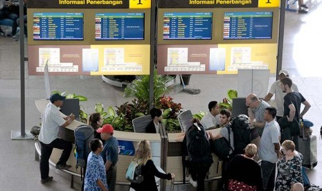 Sejumlah warga negara asing memastikan jadwal penerbangan di Terminal Internasional Bandara Ngurah Rai, Denpasar, Selasa (10/11).    (Antara/Nyoman Budhiana)