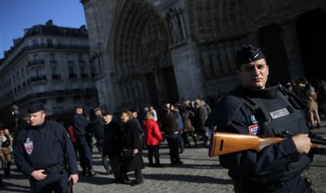  Polisi Prancis berjaga di Kota Paris, Ahad (15/11).  (AP/Christophe Ena)  