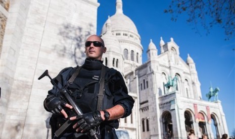  Polisi Prancis berjaga di depan Sacre Coeur Basilica, Paris, Ahad (15/11).  (AP/Kamil Zihnioglu)  