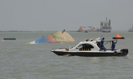 Petugas kepolisian mencari korban KM Wihan Sejahtera yang tenggelam di perairan dekat dermaga Teluk Lamong, Surabaya, Jawa Timur, Senin (16/11).  (Antara/Zabur Karuru)