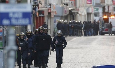 Polisi mengamankan kawasan Saint-Denis di utara kota Paris, Rabu (18/11).  (AP/Francois Mori)