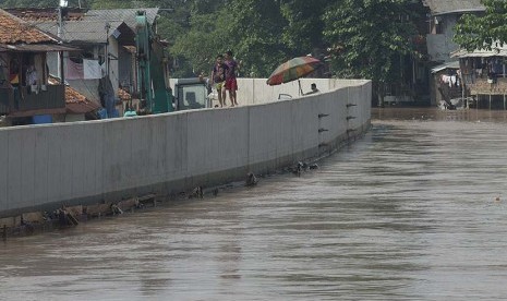 Dua orang bocah berjalan di atas turap di kawasan proyek normalisasi Sungai Ciliwung, Kampung Pulo, Jatinegara, Jakarta Timur, Rabu (25/11). (Antara/Widodo S. Jusuf)