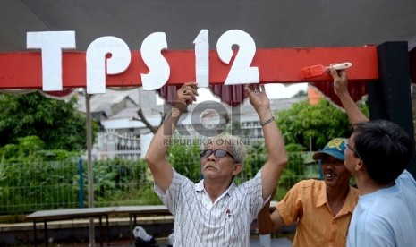 Warga mendirikan TPS 12 jelang Pilkada Serentak di Depok, Jawa Barat, Selasa (8/12).  (Republika/Wihdan)