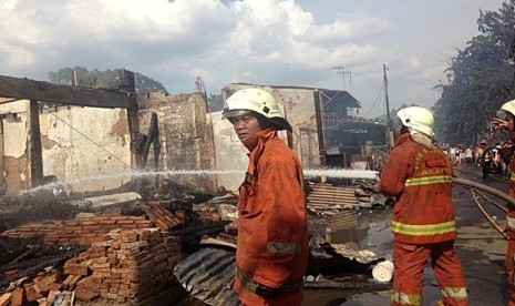  Petugas pemadam kebakaran memadamkan api kebakaran yang terjadi di jalan Bukit Duri Pangkalan, Tebet, Jakarta Selatan, Kamis (24/12).  (Republika/Maman Sudiaman)