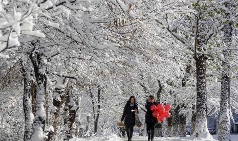   Warga melintasi jalan yang diselimuti salju putih di Almaty, Kazakhstan.  (Reuters//Shamil Zhumatov)