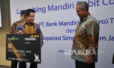 Direktur Bisnis dan Jaringan Bank Mandiri Hery Gunardi, Ketua Umum Koperasi Simpan Pinjam (Kospin) Jasa Andi Arslan (dari kiri) memperlihatkan dummy usai penandatanganan kerjasama penerbitan kartu co branding di Jakarta, Kamis (3/10).