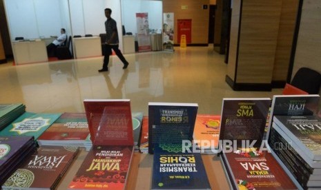 Penjaga stand merapikan buku-buku yang dipamerankan pada rangkaian acara 1st International Conference On Religion and Education (INCRE) di Bintaro, Tanggerang Selatan, Banten, Selasa (8/10).