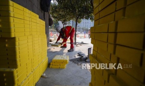 Pekerja menyelesaikan pemasang guiding block atau ubin pengarah bagi penyandang disabilitas di trotoar Bundaran HI, Jakarta, Jumat (11/10/2019).