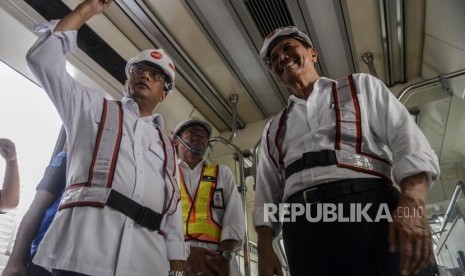 Menteri Koordinator Bidang Kemaritiman Luhut Binsar Panjaitan (kanan) dan Menteri Perhubungan Budi Karya Sumadi (kiri) saat meninjau bagian dalam gerbong LRT di Stasiun Harjamukti, Depok, Jawa Barat, Ahad (13/10).