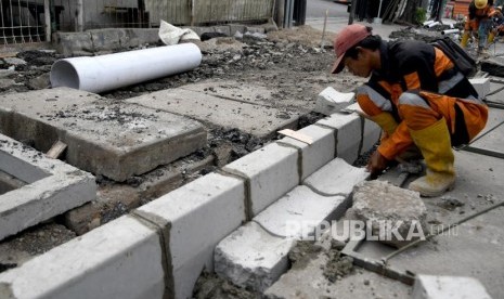 Pekerja menyelesaikan proyek revitalisasi trotoar di Jalan Kramat Raya, Jakarta Pusat, Senin (7/10/2019).