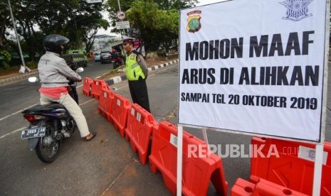 Anggota Kepolisian mengatur lalu lintas saat dilakukan penutupan jalur dikawasan Gedung DPR RI Senayan, Jalan Gatot Soebroto, Jakarta, Jumat (18/10/2019).