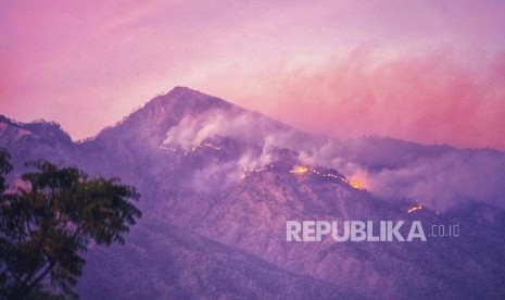 Kebakaran kawasan hutan pelawangan Senaru Gunung Rinjani terlihat menjelang matahari terbit dari Desa Anyar, Kecamatan Bayan, Lombok Utara, NTB, Ahad (20/10/2019).