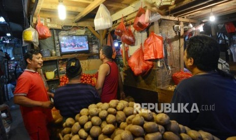 Pedagang sayuran menyaksikan acara pelantikan Presiden dan Wakil Presiden di Pasar Senen, Jakarta, Ahad (20/10/2019).