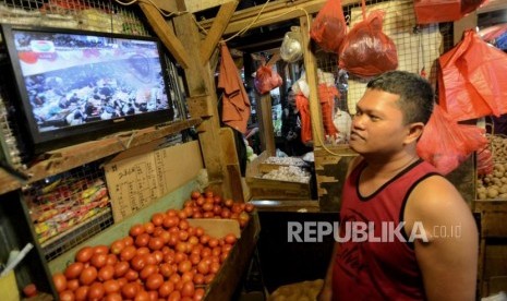 Pedagang sayuran menyaksikan acara pelantikan Presiden dan Wakil Presiden di Pasar Senen, Jakarta, Ahad (20/10/2019).