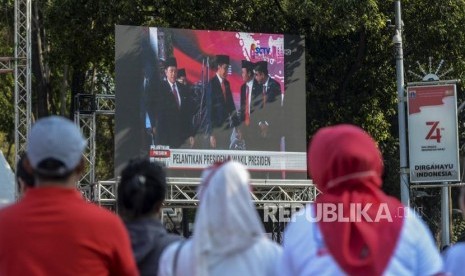 Relawan saat nonton bareng pidato Presiden Republik Indonesia periode 2019-2024, Joko Widodo di depan Istana Merdeka, Jakarta, Ahad, (20/10).