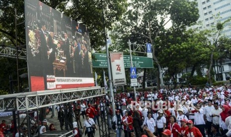 Relawan saat nonton bareng pidato Presiden Republik Indonesia periode 2019-2024, Joko Widodo di depan Istana Merdeka, Jakarta, Ahad, (20/10).