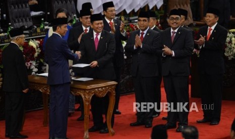 Ketua MPR RI Bambang Soesatyo berjabat tangan dengan Presiden Joko Widodo saat acara pelantikan Presiden dan Wakil Presiden periode 2019-2024 di Gedung Nusantara, kompleks Parlemen, Senayan, Jakarta, Ahad (20/10).