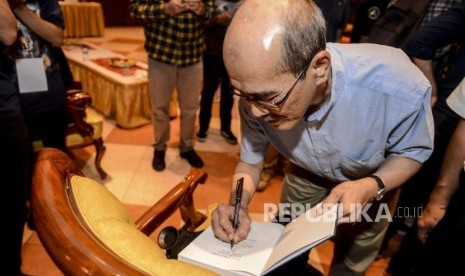 Ekonom Senior Faisal Basri menandatangani bukunya usai diskusi dan peluncuran buku Menuju Indonesia Emas di Jakarta, Senin (21/10).