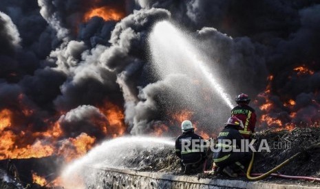 Petugas Pemadam Kebakaran berusaha memadamkan api di lokasi terjadinya kebakaran pipa bahan bakar minyak Pertamina di Kecamatan Melong, Kota Cimahi, Selasa (22/10).