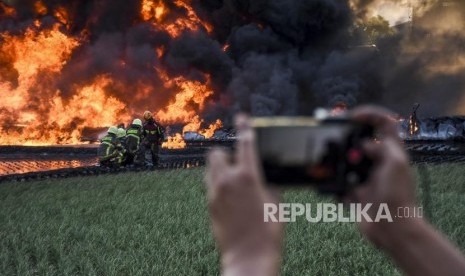 Petugas Pemadam Kebakaran berusaha memadamkan api di lokasi terjadinya kebakaran pipa bahan bakar minyak Pertamina di Kecamatan Melong, Kota Cimahi, Selasa (22/10).