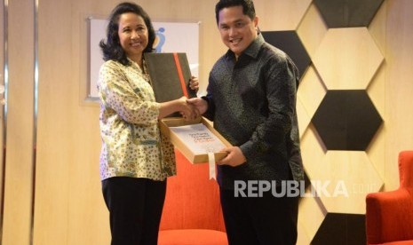 Mantan Menteri BUMN Rini Soemarno memberikan buku laporan kinerja kepada Menteri BUMN Erick Thohir pada acara serah terima jabatan di Kementerian BUMN, Jakarta, Rabu (23/10).