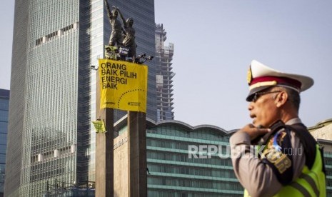 Aktivis Greenpeace membentangkan spanduk saat menggelar aksi di Monumen Selamat Datang, Bundaran HI, Jakarta, Rabu (23/10/2019).