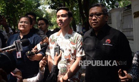 Putra Presiden Joko Widodo Gibran Rakabuming Raka didampingi Sekjen PDIP Hasto Kristiyanto bersiap memberikan pertanyaan wartawan seusai melakukan pertemuan tertutup dengan Ketum PDIP Megawati Soekarnoputri di kediaman Megawati di Jalan Teuku Umar, Menteng, Jakarta, Kamis (24/10).