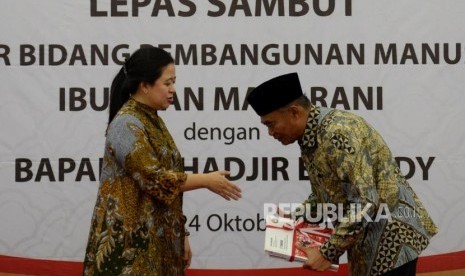 Mantan Menteri Koordinator Bidang Pembangunan Manusia dan Kebudayaan (PMK) yang juga Ketua DPR Puan Maharani berjabat tangan dengan Menko PMK Muhadjir Effendy pada acara lepas sambut di Kantor Kemenko PMK, Jakarta, Kamis (24/10).