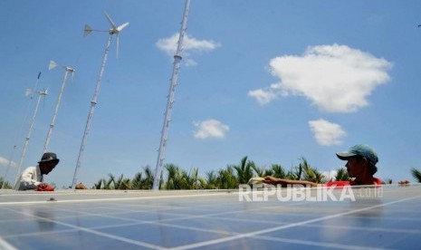 Pembangkit Listrik Tenaga HybridWarga membersihkan panel surya di Energi Mandiri Tenaga Surya dan Angin ( E Mas Bayu), Kampung Laut, Cilacap, Jawa Tengah, Kamis (24/10).