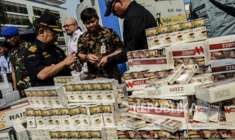 Petugas melihat rokok hasil penindakan barang kena cukai saat konferensi pers di Jakarta, Jumat (25/10).