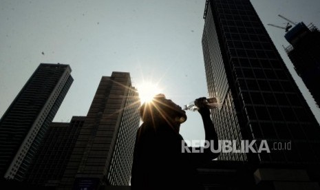 Warga meminum air saat cuaca panas di kawasan Bundaran Hotel Indonesia, Jakarta, Jumat (25/10/2019).