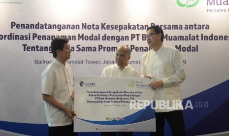 Chief Executive Officer Bank Muamalat Achmad K.Permana (kanan) dan Komisaris Utama Bank Muamalat Ilham Akbar Habibie (tengah)  berbincang bersama Deputi Kepala Bidang Kerjasama Penanaman Modal BKPM Wisnu Wijaya Soedibjo (kiri) usai melakukan penandatanganan kerjasama di Jakarta, Jumat (25/10).