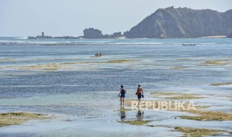 Wisatawan mancanegara berjalan saat air surut di pantai Mandalika, Desa Kuta, Kecamatan Pujut, Praya, Lombok Tengah, NTB, Senin (28/10/2019).