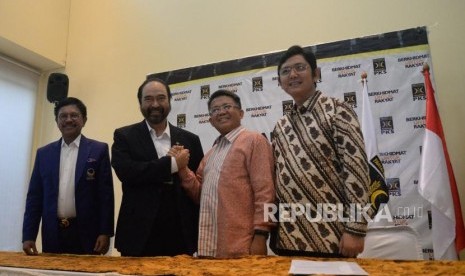 Ketua Umum Partai NasDem Surya Paloh (dua kiri) berjabat tangan dengan Presiden PKS Mohamad Sohibul Iman (dua kanan) didampingi Sekjen Partai NasDem Jonny G Plate (kiri) dan Sekjen PKS Mustafa Kamal (kanan) memberikan keterangan usai melakukan pertemuan di Kantor DPP PKS, Jakarta, Rabu (30/10).